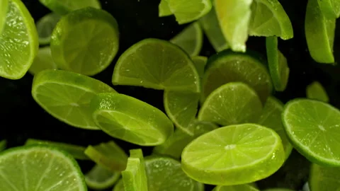Fresh limes slices vortex on black background, slow motion Stock Footage 246310712