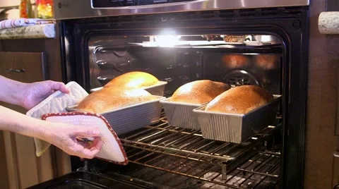 Fresh loaves of bread being removed from oven Stock Footage 45618468