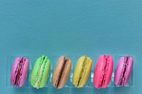 Fresh macaroons on blue background with copy space, top view, shallow depth o Stock Photos