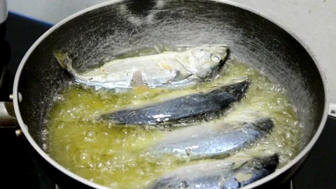 Fresh mackerel fish frying in a hot pan with sizzling oil Stock Footage 336229802