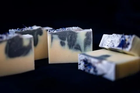 Fresh made bars of handmade soap lying on the dark cloth Stock Photos