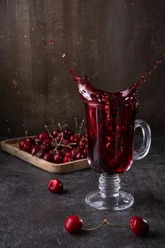 Fresh made Cherry Juice with splashes on wooden background Stock Photos