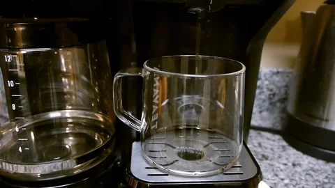 Fresh made coffee dripping from a machine into a glass cup Stock Footage 96049026