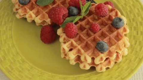 Fresh made waffles with blueberries and raspberries rotating Stock Footage 80646173