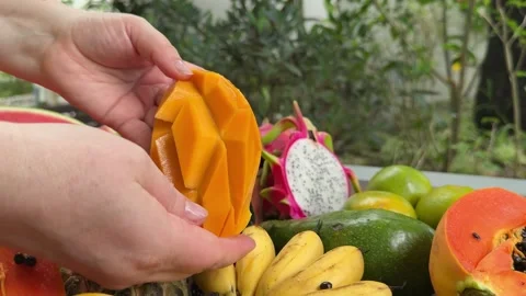 Fresh mango and its sliced pieces on a wooden table, showcasing vibrant tropical Stock Footage 306285630