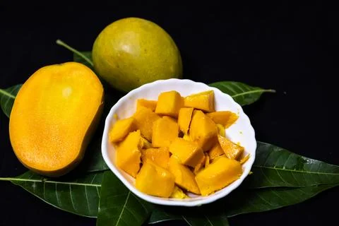Fresh mango cubes served in white bowl with ripe tropical fruit presentation Stock Photos