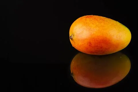 Fresh mango fruit on black background with reflection Stock Photos