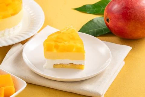 Fresh mango mousse cake served on a white plate. Stock Photos