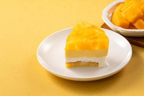 Fresh mango mousse cake served on a white plate. Stock Photos