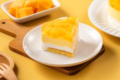Fresh mango mousse cake served on a white plate. Stock Photos