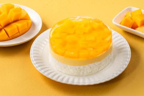 Fresh mango mousse cake served on a white plate. Stock Photos