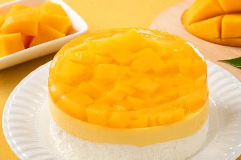 Fresh mango mousse cake served on a white plate. Stock Photos