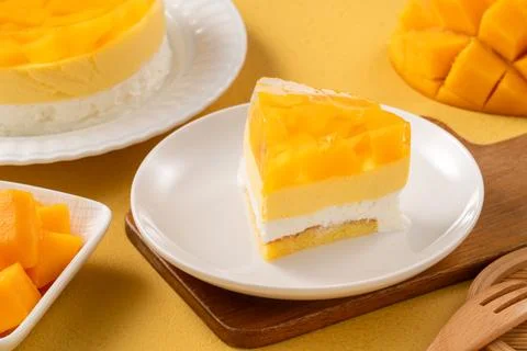Fresh mango mousse cake served on a white plate. Stock Photos