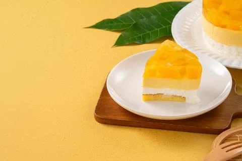 Fresh mango mousse cake served on a white plate. Stock Photos