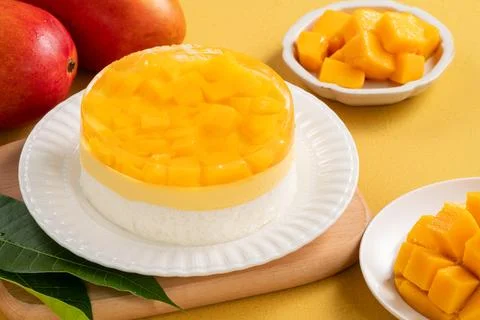 Fresh mango mousse cake served on a white plate. Stock Photos
