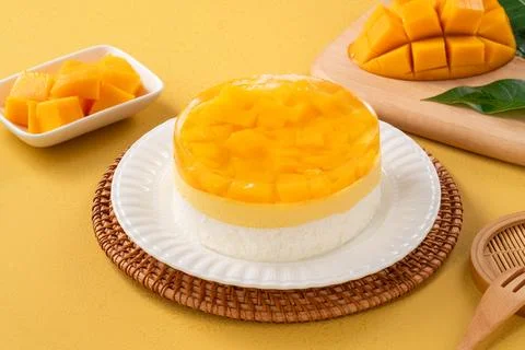 Fresh mango mousse cake served on a white plate. Stock Photos