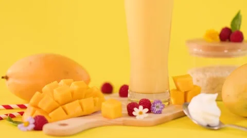 Fresh Mango Smoothie with Tropical Fruit on Yellow Background Stock Footage 323780511