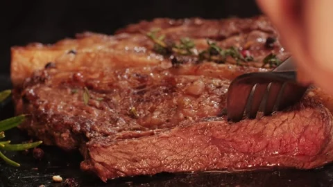 Fresh marbled beef with pepper, salt and rosemary close-up macro. Cutting with Stock Footage 265164221