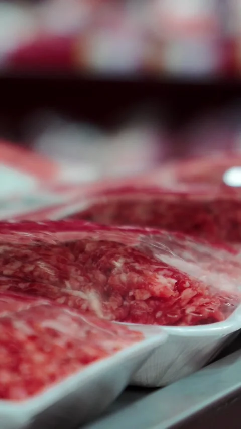 Fresh marbled raw beef packaged neatly on white trays inside refrigerated Stock Footage 346774408