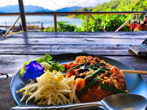Fresh meal served on a plate with a view of water and mountains during dayt.. Stock Photos