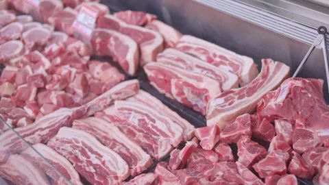 Fresh meat display features various cuts at butcher counter, beef ribs and pork Stock Footage 319912056