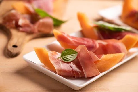 Fresh melon and parma ham on white plate Stock Photos