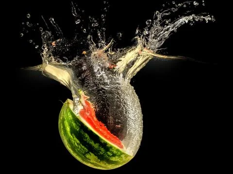 Fresh melon falling in water with splash on black background Stock Photos