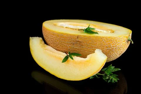 Fresh melon half with basil leaves on black studio background Stock Photos