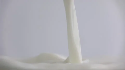 Fresh milk drop falling and splashing in a milky pool. Pouring milk in slow Stock Footage 335878467