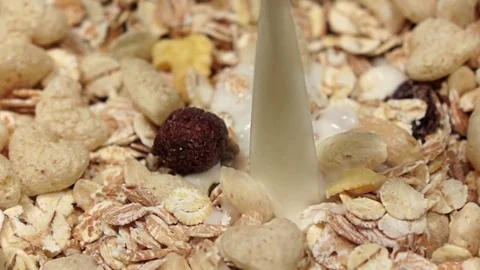 Fresh milk poured in dry breakfast, slow motion. Close up Stock Footage
