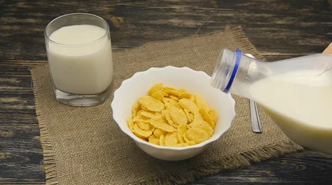 Fresh milk pouring into a bowl full of cornflakes in slowmotion Stock Footage 59576539