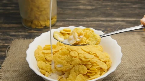 Fresh milk pouring into a bowl full of cornflakes in slowmotion Stock Footage 59588274