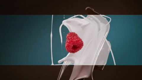 Fresh milk splash falling in slow motion with raspberry Stock Footage 253699377