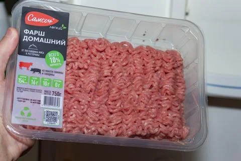 Fresh minced meat in plastic container held by hand Stock Photos
