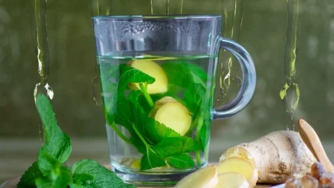 Fresh mint-ginger tea with running water in the background Stock Footage 122336583