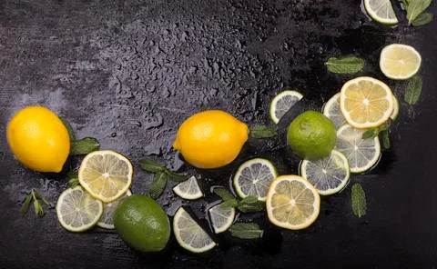 Fresh mint, lime and ice on a black background. Ingredient for mahito. Stock Photos