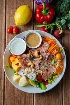 Fresh mixed vegetable and fruit salad bowl with crispy bacon, sesame dressi.. Foto stock
