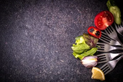 Fresh mixed vegetables on fork on black background Stock Photos