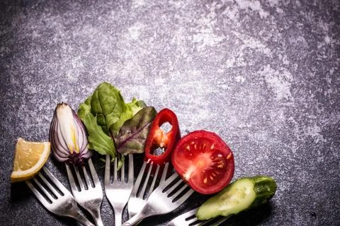 Fresh mixed vegetables on fork on black background Stock Photos