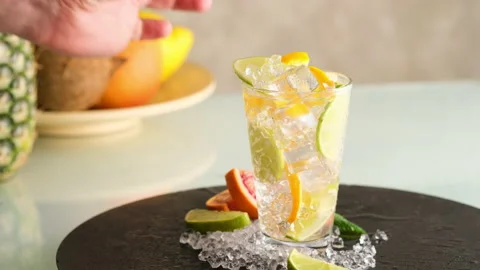 Fresh mojito. Bartender puts a leaf of green mint into the glass with mojito Video stock 130743610