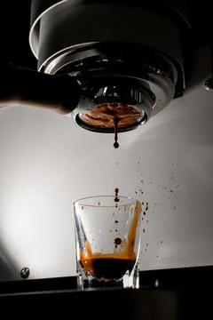 Fresh morning espresso with crema pouring through portafilter. Close-up. Process Stock Photos