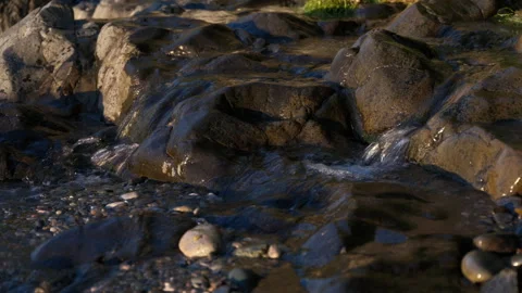 Fresh Mountain Stream Flowing Over Coastal Rocks Video stock 347983943