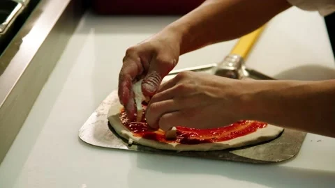 Fresh mozzarella put onto pizza sauce and dough in restaurant, slow motion Stock Footage 229808915