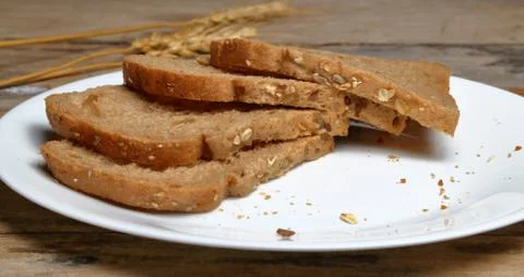 Fresh multi grain bread in a ceramic plate on wooden background Stock Photos
