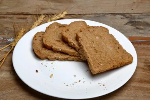 Fresh multi grain bread in a ceramic plate on wooden background Stock Photos