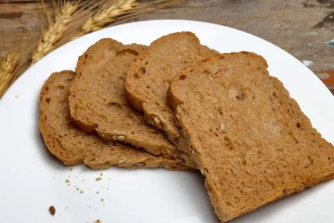Fresh multi grain bread in a ceramic plate on wooden background Stock Photos