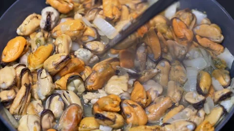 Fresh mussels heating inside dry pan, top view, steam lifting above shiny shells Video stock 321817866