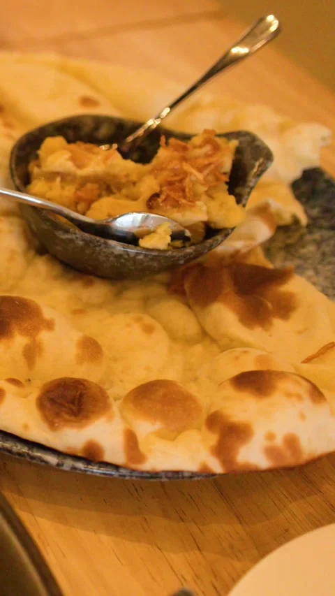 Fresh Naan Flatbread Served with Savory Chickpea Dip on Restaurant Table Stock Footage 345471027