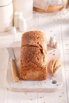 Fresh oat bread baked in a rustic bright kitchen. Stock Photos