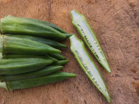 Fresh okra slice and fruit on wooden background. Foto stock